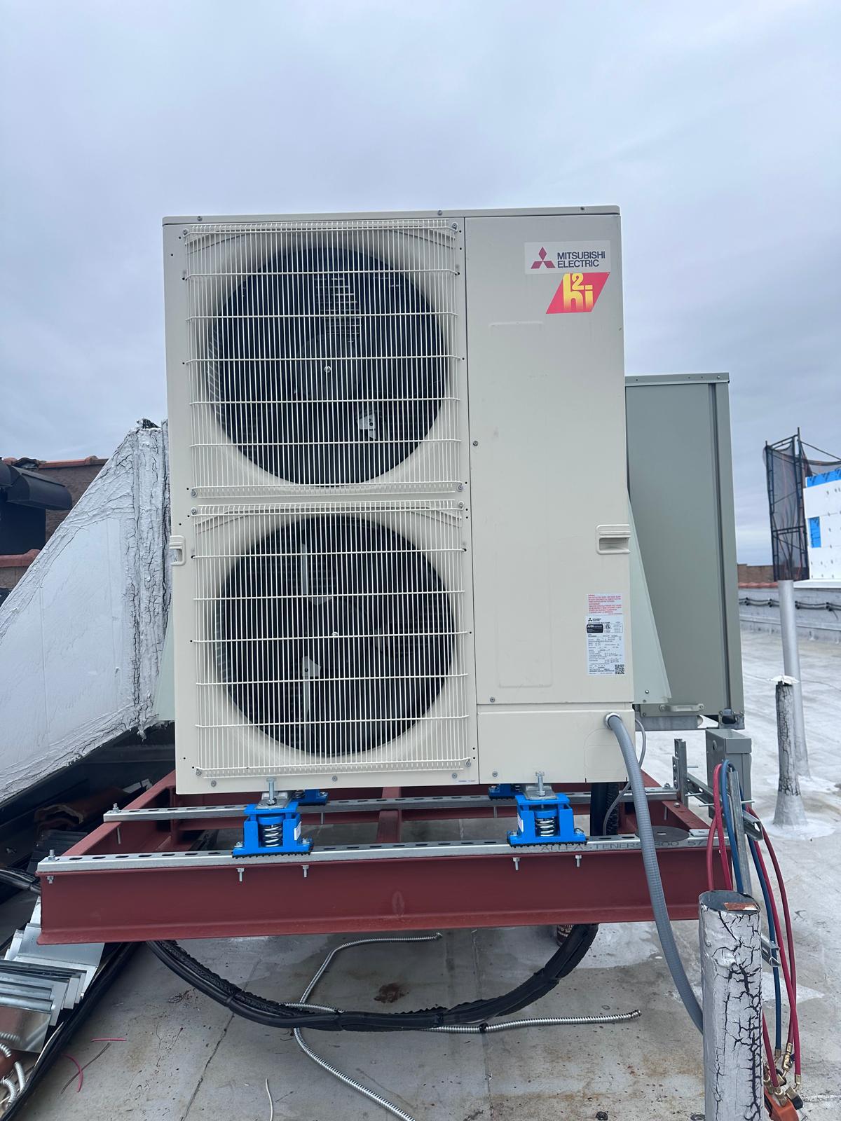 Mitsubishi heat-pump condenser on spring isolators on a New York rooftop