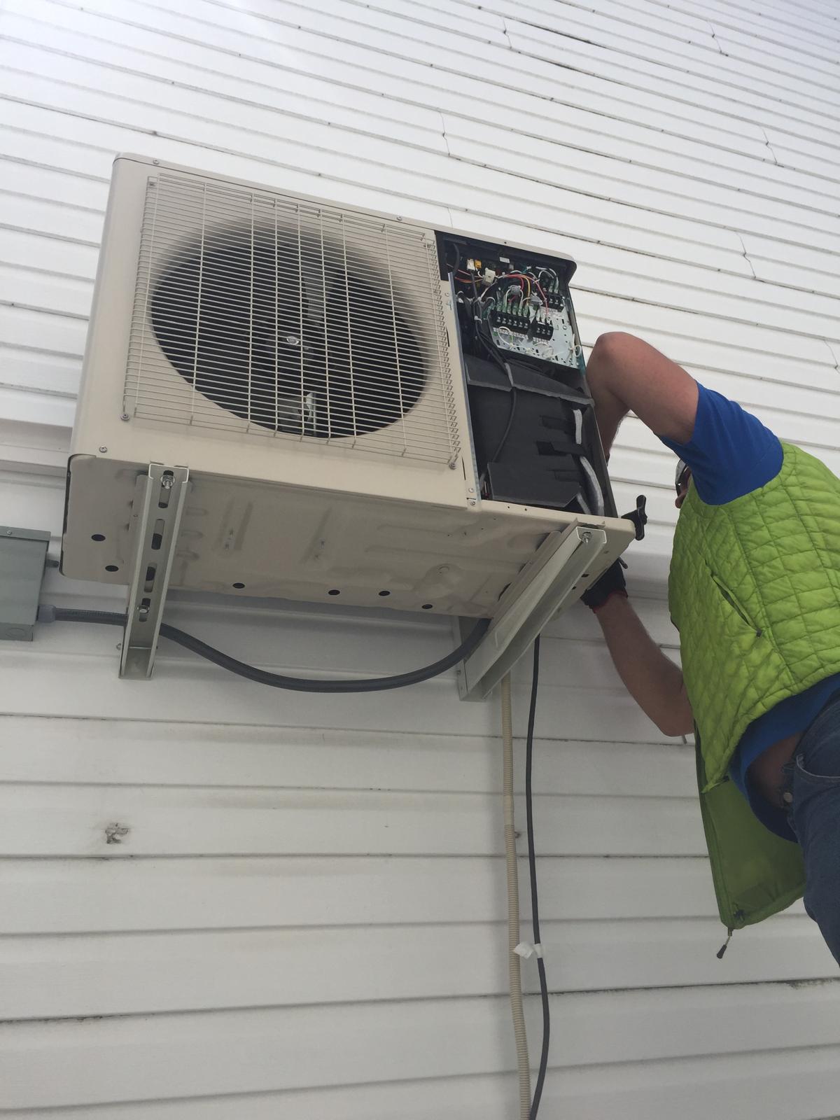 Technician working on an outdoor air conditioning unit