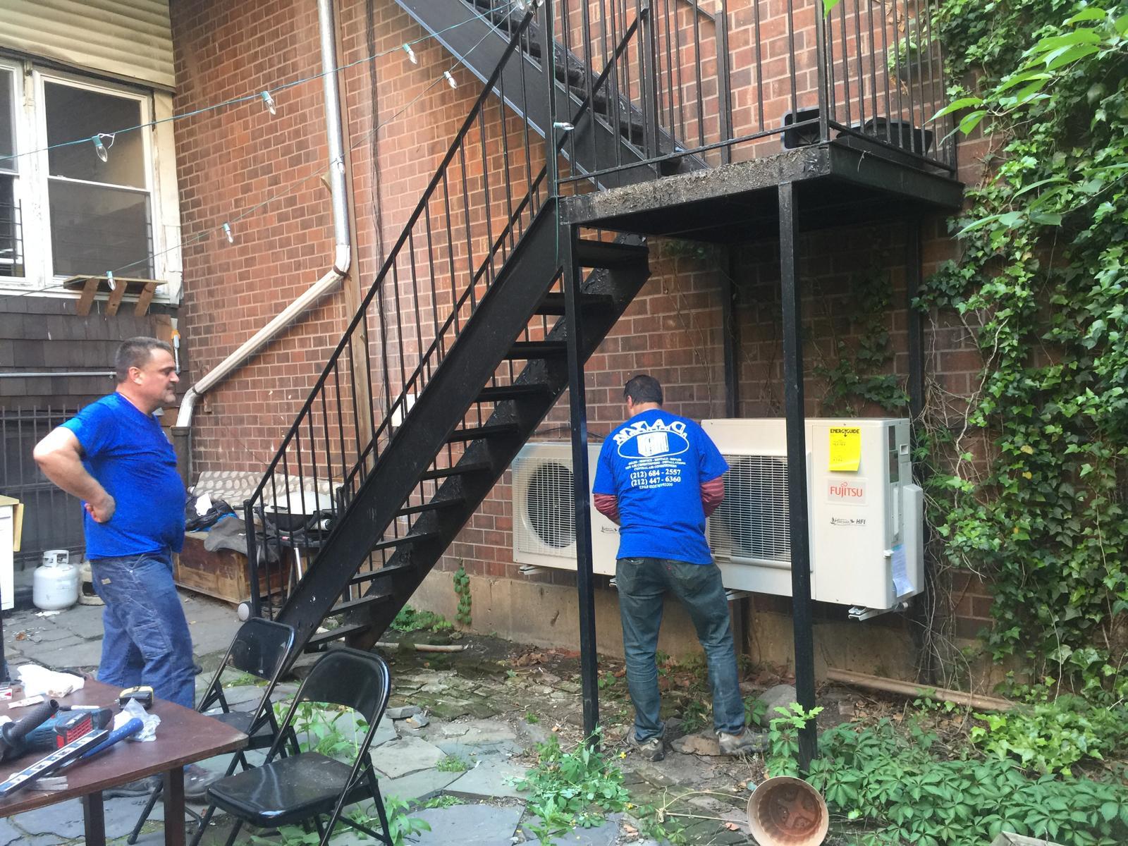 Technician checking an air conditioning unit during a service visit
