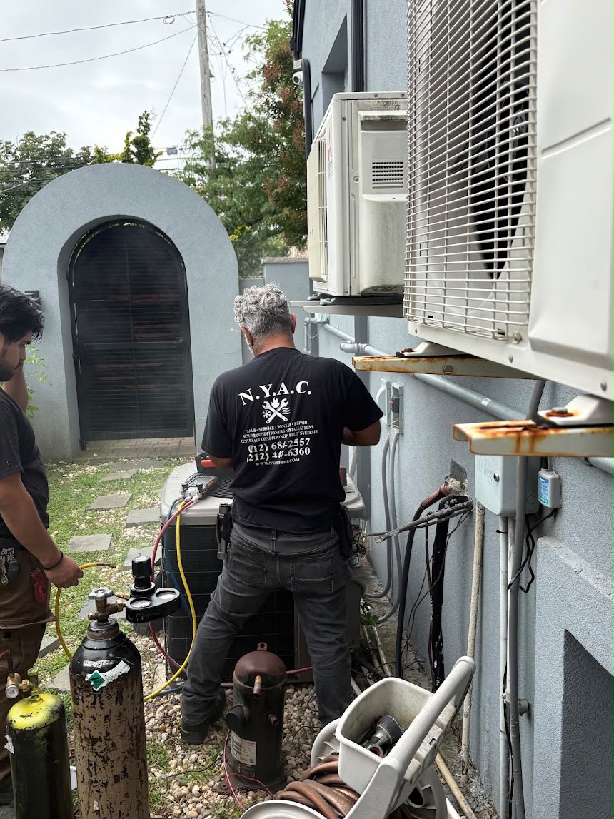 HVAC technician beside outdoor air conditioning equipment