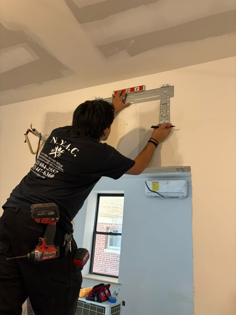 N.Y.A.C. technician positioning an indoor mini-split mounting bracket
